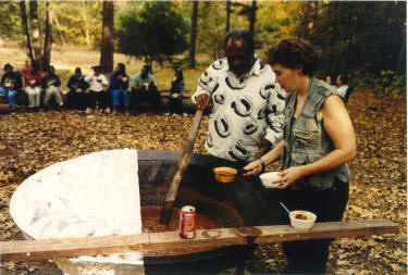 Nancy Studinski stirs the chili with George Jenkins assistance.