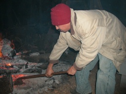 Ron Cox Jr shoveling coals for the raosting pit, By Greer Geiger